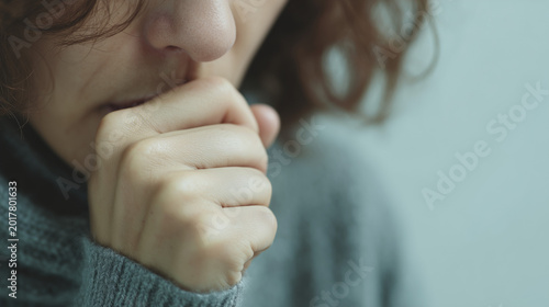 Person covering mouth while coughing indoors, respiratory illness and hantavirus symptom concept in close-up view