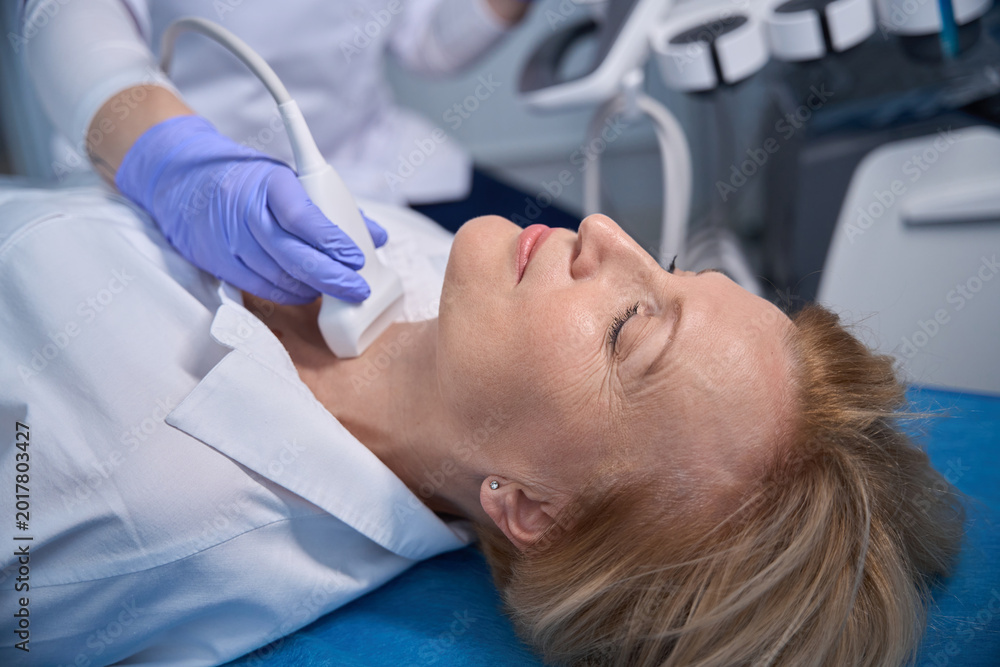 Fototapeta premium Serene woman undergoing ultrasound examination in medical room