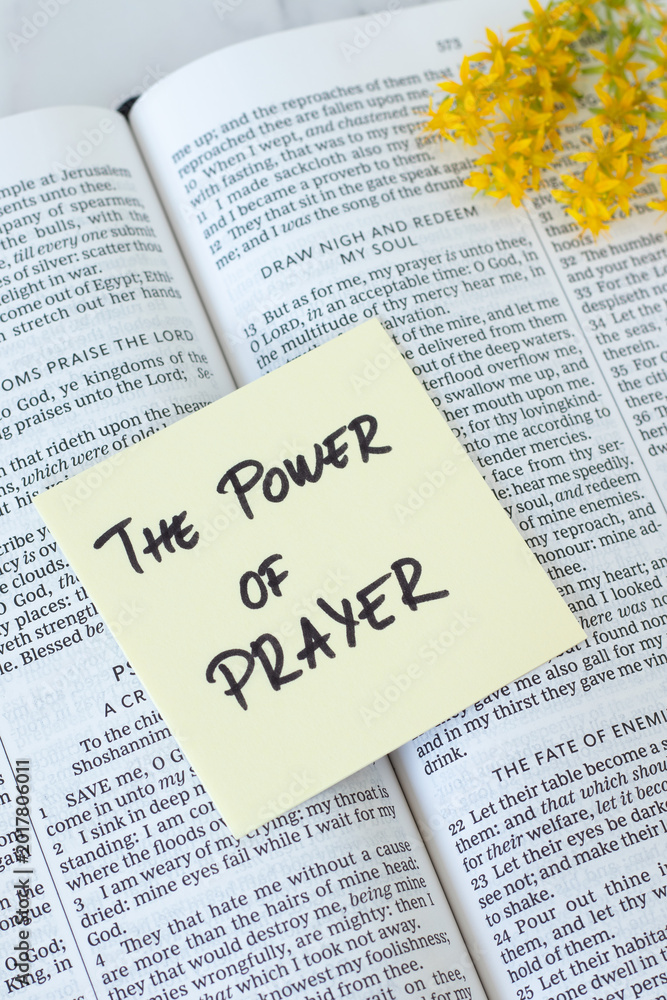Obraz premium The power of prayer, handwritten text on a note with holy bible book. Christian biblical concept.