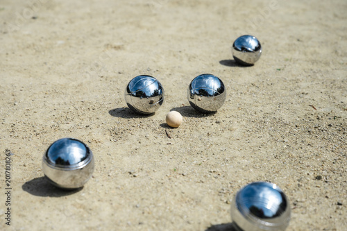 Fotografía Detailed view of petanque court with scattered steel balls on textured sand and