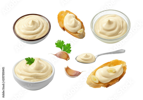 Creamy garlic mayonnaise and aioli presented in bowls, on crostini and a spoon, garnished with garlic cloves and parsley on a transparent background