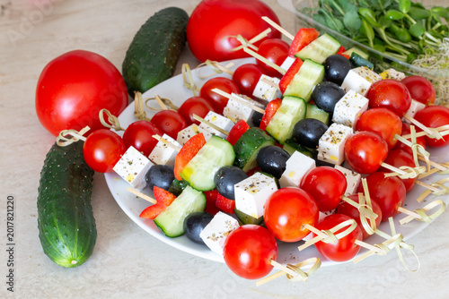 Fresh vegetable and cheese appetizer skewers on white plate healthy snack concept