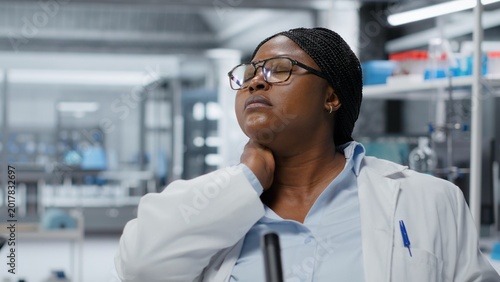 Foto Researcher relaxing strained muscles in laboratory while using laptop software, driving treatment discovery