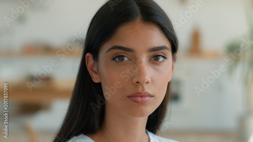 Konstfotografi Serious pensive Indian Arabian woman looking at camera thinking at home indoors