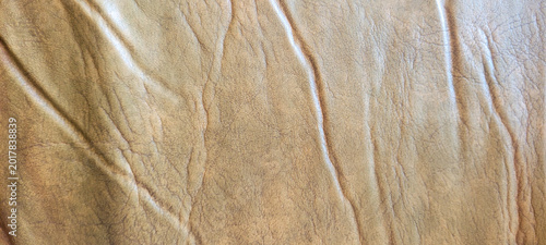 Brown faux leather texture with natural wrinkles, soft matte finish, organic folds, vintage upholstery appearance, and realistic synthetic leather background.