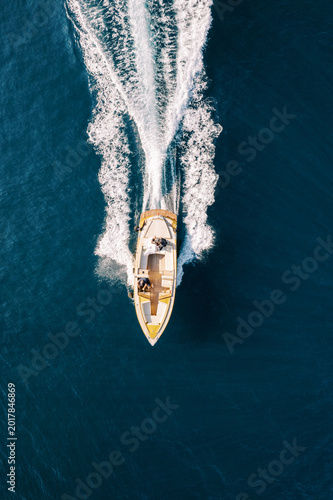 Tableau sur toile Unmanned aerial vehicle films swift yellow vessel afloat