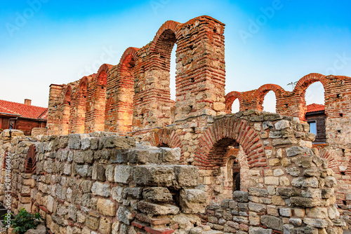 фотографія Ancient roman ruins with brick archways under clear blue sky