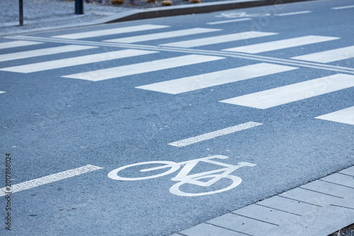 Obraz na plátne Bicycle lane marking on asphalt road with pedestrian crosswalk lines visible, ur
