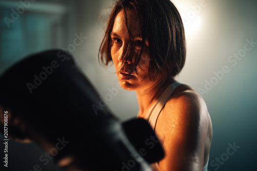 Canvastavla Female boxer training hard, sweating, focusing on intense workout, building stre