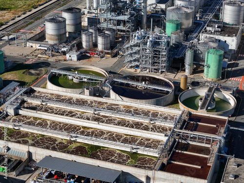 Aerial view of the chemical plant industrial facility featuring large circular settling tanks and aeration basins Crescentino, Piedmont, Italy.