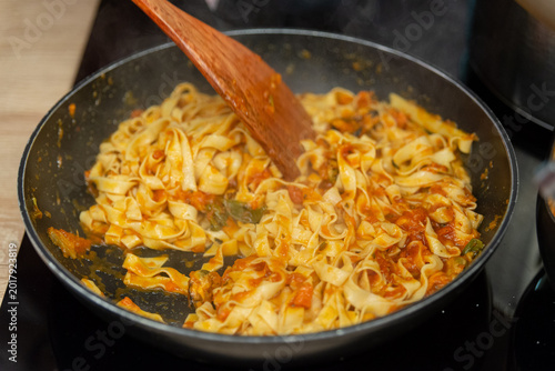 Bild auf Leinwand Simmering fettuccine pasta with tomato sauce in frying pan for fresh homemade it