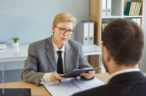 Interview resume review by recruiter and candidate. In a bright office, the hiring manager assesses skills and experience during formal business job interview. Professional recruitment process.