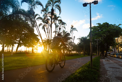 Cyclist Riding on a Coastal Bike Path in Santos, Brazil at Sunset