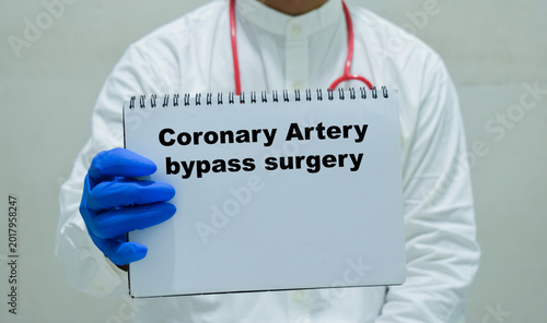 Fotografie Doctor holds in hands a book with the name of the coronary artery bypass surgery