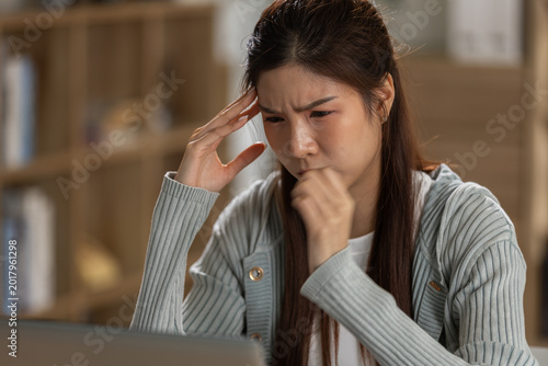 Cuadro en lienzo Asian woman stressed having headache sick using laptop in office working tired a