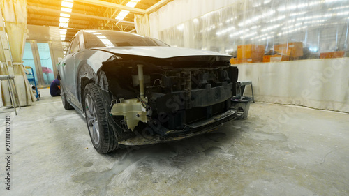 Bild auf Leinwand damaged car side skirt undergoing repaint after a heavy collision in an auto body workshop