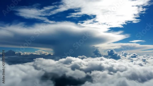 A breathtaking aerial view showcases a vast expanse of fluffy white clouds stretching across a brilliant blue sky, illuminated by the radiant glow of the sun.