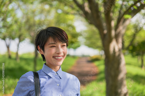 新緑を背景に笑顔の女性のクローズアップ