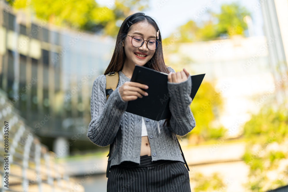 Fototapeta premium Education concept, Happy asian female university student reading educational book, Smiling young woman enjoy studying and learning, Higher education, academic knowledge, college campus and lifestyle