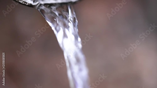 A strong stream of water flows from a drainpipe close-up