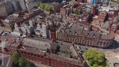 Cinematic drone footage above historic Victorian red brick buildings and old architecture in Birmingham city centre, England with detailed urban landscape and city streets.