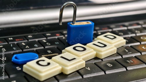 Tablou pe pânză An open blue padlock and key sit atop a keyboard spelling CLOUD, highlighting security vulnerabilities and the necessity of data protection within shared remote computing environments