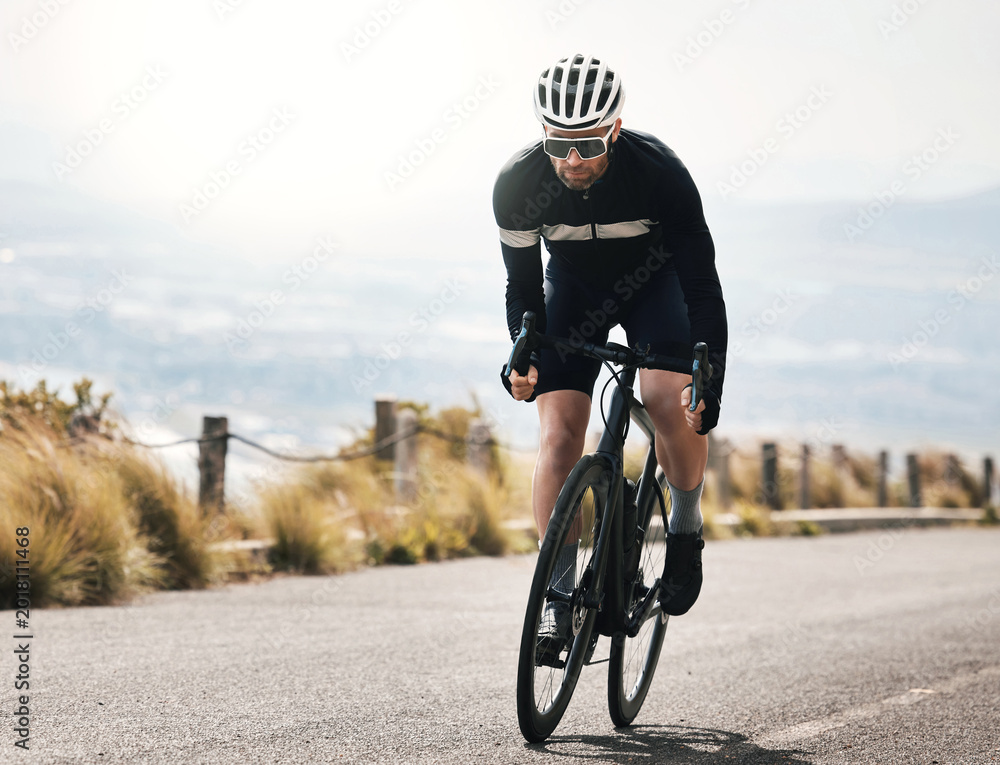 Obraz premium Fitness, cycling or man on road with bike, endurance training or challenge in cardio workout. Serious, space or mature cyclist outdoor on bicycle, physical activity or riding practice in sports hobby