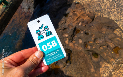Tourist Hand Showing Entry Ticket With Distance Instruction at Iguazu Waterfalls Platform.
