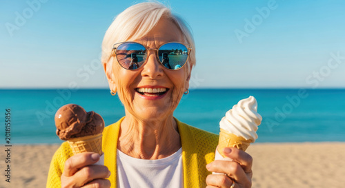 Senior woman with short white hair holds two ice cream cones, one chocolate and one vanilla, against a beach and ocean backdrop