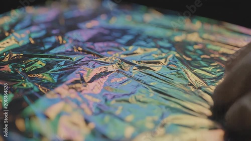 A close-up of crinkled, iridescent material reflecting a spectrum of colors