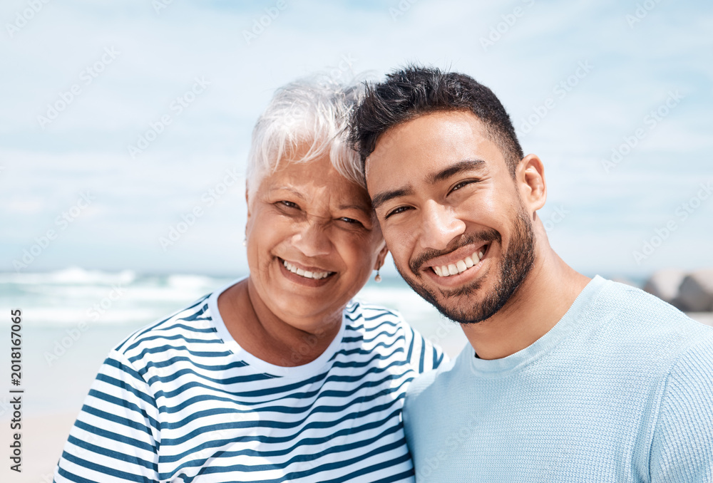 Fototapeta premium Happy, portrait and man with senior mother at beach for summer holiday, weekend trip and bonding. Love, son and elderly mom with connection at seaside for vacation smile, retirement support or travel