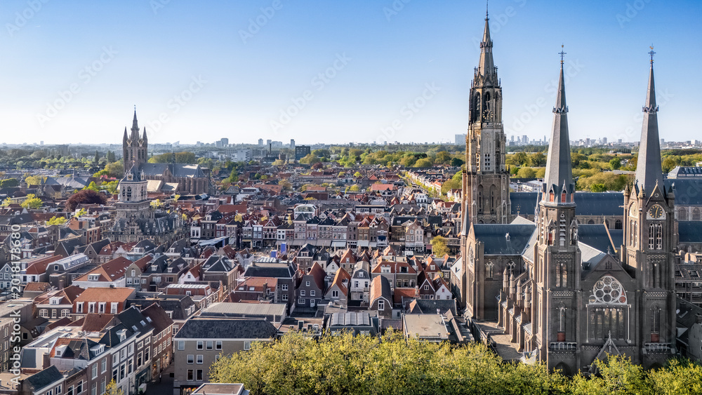 Obraz premium Aerial drone view of Delft with historic cathedrals, panoramic cityscape of old town Delft with traditional Dutch architecture, market square and city center, the Netherlands