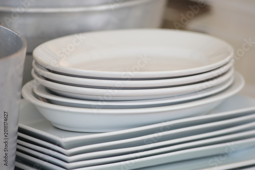 Foto Stack of Clean White Ceramic Plates and Platters in a Professional Kitchen