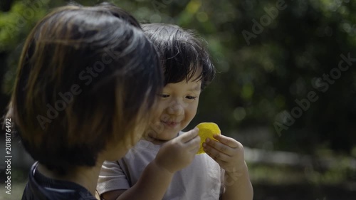 Happy Mom Holding Little Child Enjoying A Traditional Fruit Snack 01