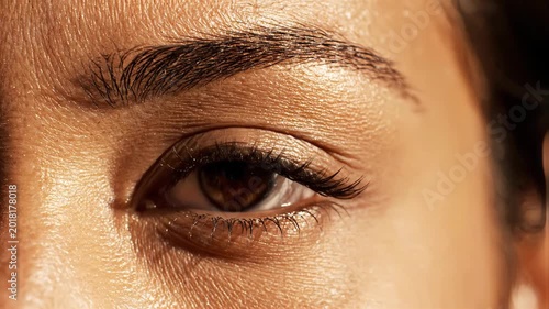 Extreme macro shot of a human eye with brown iris and finely detailed skin