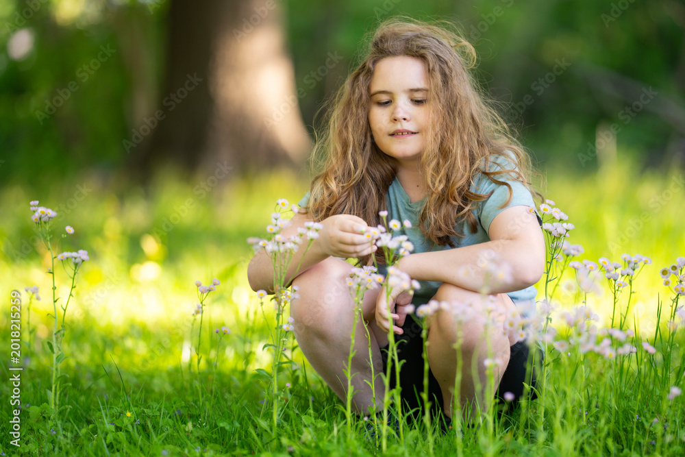 Obraz premium Wildflowers surround smiling child outdoors. Summer wildflowers create scenic background. Wildflowers add cheerful spring mood. Wildflowers portrait feels bright and joyful.
