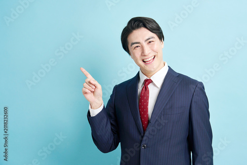 左を指差す笑顔のビジネスマン