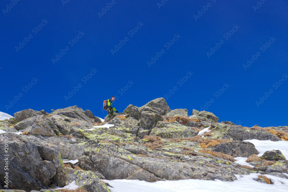 Fototapeta premium Alpinista sulla cresta rocciosa verso la vetta