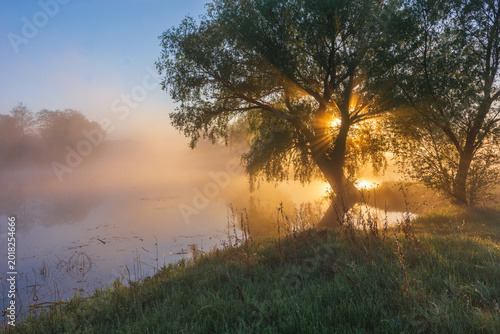 Fotografie a misty sunrise over a calm river