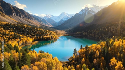 Stunning aerial view of Kanas Lake in autumn with vibrant fall foliage and snowy mountains