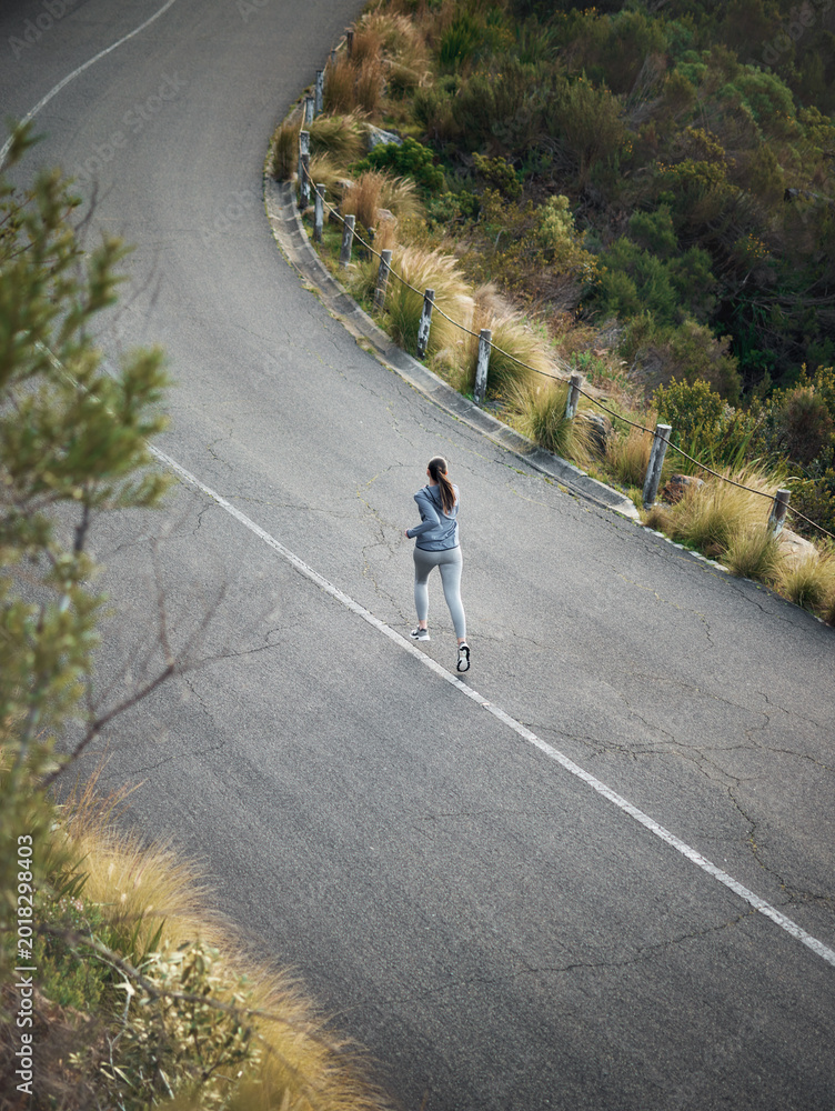 Naklejka premium Fitness, woman and workout with running in road for pace training, endurance challenge or wellness. Above, back or athlete with morning jog on space for sports performance, cardio practice or health