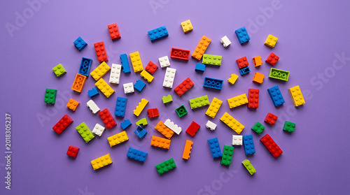 Colorful LEGO circular pattern on a vibrant purple background with copy space