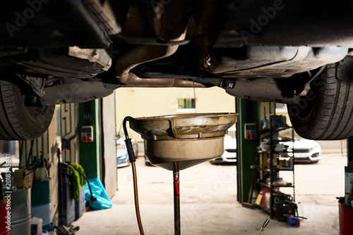 Fotografie Close-up of black motor oil draining from a car engine during service