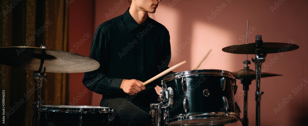 Fototapeta premium The drummer is sculpting rhythms on a sleek black drum kit like a sound magician.