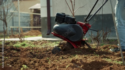 Motor cultivator standing on freshly tilled garden soil