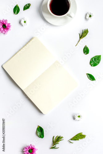 Foto Petals, cup and copybook on table background top view mock up