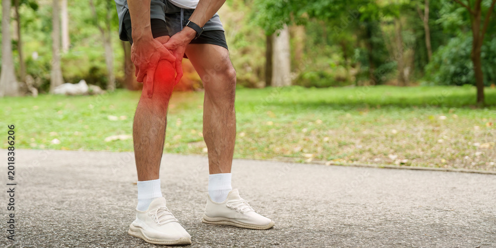 Fototapeta premium Asian man with knee pain during outdoor sport activity in park