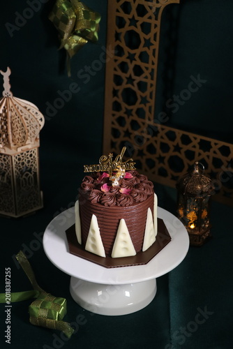 Chocolate cake (sponge, mousse, crunch, sauce) arranged artistically and separated on the plate, with Eid Mubarak topper.