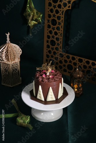 Chocolate cake (sponge, mousse, crunch, sauce) arranged artistically and separated on the plate, with Eid Mubarak topper.