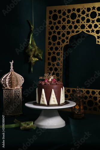 Chocolate cake (sponge, mousse, crunch, sauce) arranged artistically and separated on the plate, with Eid Mubarak topper.
